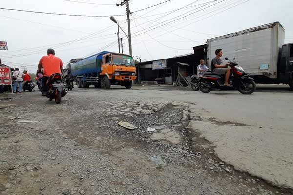 RUSAK: Pengendara melintas di jalan berlubang di Jalan Pancing 1, Kelurahan Besar, Medan Labuhan.fachril/sumut pos.