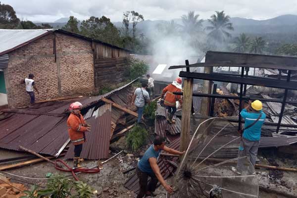 TERBAKAR: Warga di Dusun Kuta Mbaru, Desa Harapan Kecamatan Tanah Pinem Kabupaten Dairi membantu petugas pemadam kebakaran saat memadamkan api yang membakar dua rumah.