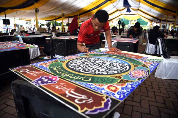 SERIUS: Para peserta serius menyelesaikan karyanya pada lomba kaligrafi golongan dekorasi pada MTQ ke-37 Provinsi Sumatera Utara, di Lapangan Merdeka Kota Tebingtinggi, Minggu (6/9). 
