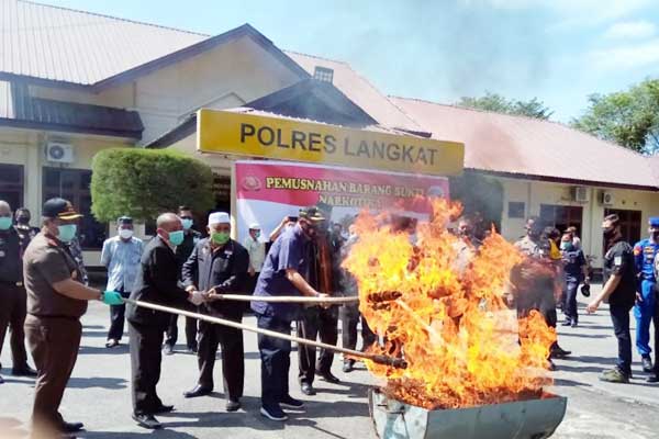 MUSNAHKAN: Kapolres Langkat, AKBP Edy Suranta Sinulingga dan Wakil Bupati Langkat, H.Syah Afandin melakukan pemusnahan ganja dengan cara dibakar. ILYAS EFFENDY/ SUMUT POS.