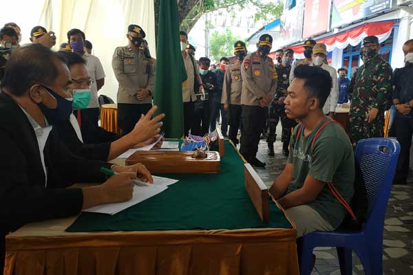 SIDANG: Seorang warga yang terjaring razia masker menjalani sidang lapangan oleh Hakim Pengadilan Negeri Medan di Lapangan Merdeka Medan, Selasa (16/9).