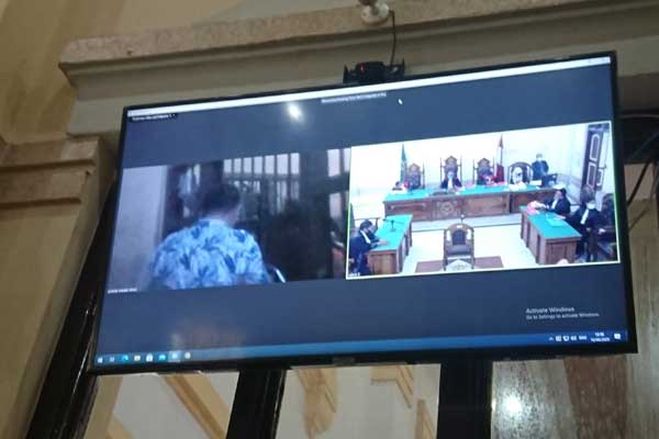 BELAKANGI: Husen Syukri (layar monitor) terdakwa kepemilikan ekstasi membelakangi majelis hakim saat men jalani sidang tuntutan secara virtual, Rabu (16/9).