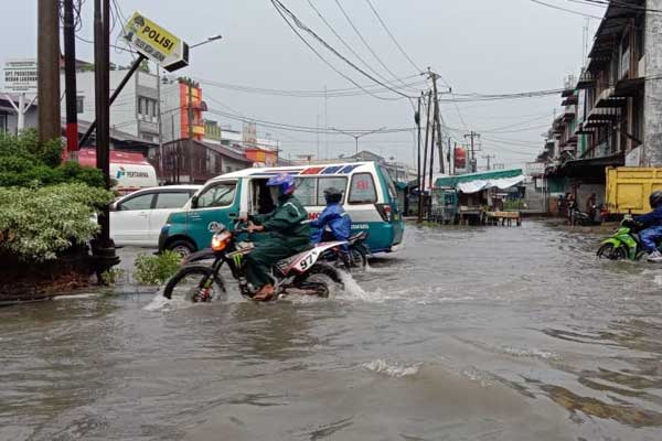 BANJIR: Pengendara melintas di genangan air di Medan Utara akibat banjir. Hujan deras kemarin merendam ribuan rumah di Medan Marelan, Medan Labuhan, Medan Deli dan Medan Belawan, Rabu (9/9).fachril/sumut pos.