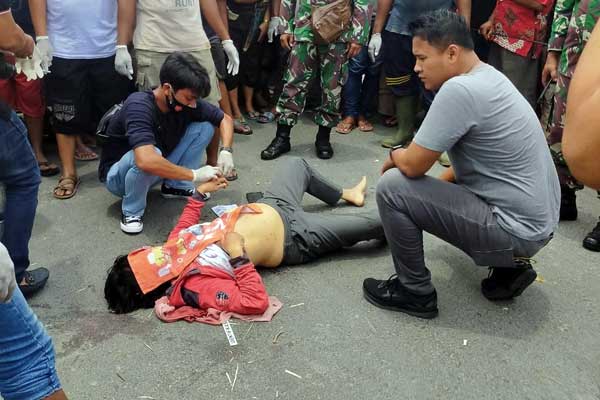 DIEVAKUASI: Jasad korban dikerumuni warga usai dievakuasi dari semak-semak usai dibunuh pelaku.