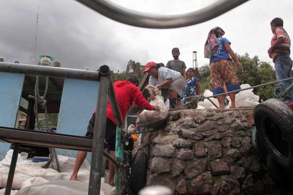 IKAN: Sejumlah ibu-ibu mendapat hatah ikan-ikan mentah OSH dari KJA Regal Spring, di Desa Sitiotio, Kecamatan Simanindo, Samosir.