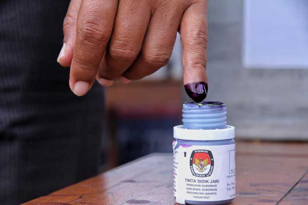 CELUP: Seorang pemilih mencelupkan jarinya ke tinda usai mencoblos. Di Pilkada 2020, pencelupan jari ke tinta ditiadakan untuk mencegah Covid-19.