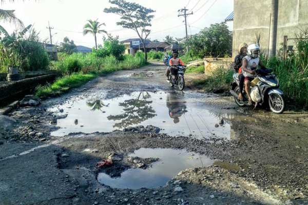 RUSAK PARAH: Pengendara sepeda motor melintasi Jalan Bakti ABRI di Kelurahan Besar, Kecamatan Medan Labuhan, yang rusak parah, Kamis (1/10). Hingga saat ini, Jalan Bakti ABRI tak kunjung diperbaiki.