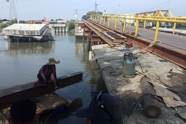 TITI DUA SICANANG: Seorang warga bersantai di dekat Jembatan Titi Dua Sicanang, Belawan. Pembangunan jembatan ini dipastikan tidak selesai tahun ini karena kekurangan anggaran.