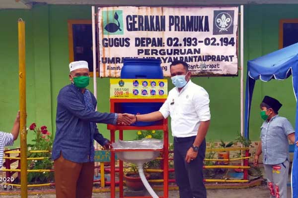 MASKER: Kepala Kelurahan Sirandorung, Kecamatan Rantau Utara, Kabupaten Labuhanbatu, M Kamisdan saat membagikan masker terkait upaya menjadikan wilayah tangguh bencana.fajar/sumut pos.