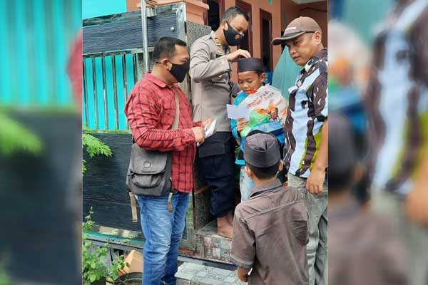 BERBAGI: Kapolsek Talun Kenas, AKP Hendra Tambunan saat memberikan Tali Asih kepada Anak-anak Yatim Piatu.