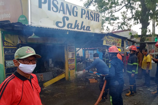 PADAMKAN API: Petugas kebakaran Kota Medan saat berupaya memadamkan api yang membakar warung pisang goreng di Jalan Mangaan III, Pasar II, Kelurahan Mabar, Kecamatan Medan Deli, Senin (12/10).