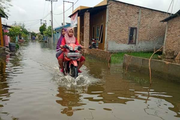 BANJIR: Pengendara motor melintasi genangan banjir di Komplek Tenaga Kerja Bongkar Muat (TKBM), Kelurahan Sei Mati, Medan Labuhan, Kamis (22/10).
