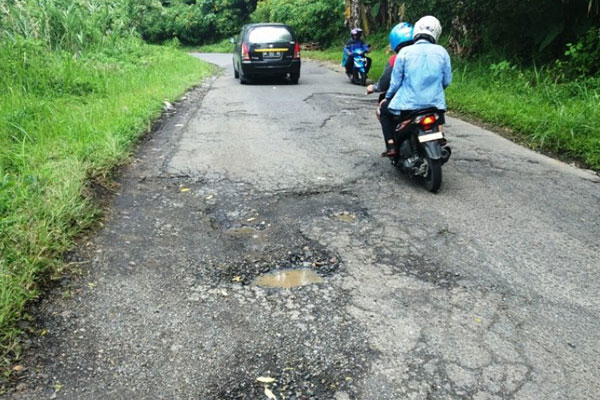 JALAN RUSAK: Pengendara melintasi jalan rusak menuju kawasan Medan Zoo. Sudah belasan tahun kondisi tersebut dibiarkan Pemko Medan, dalam hal ini PU Kota Medan.