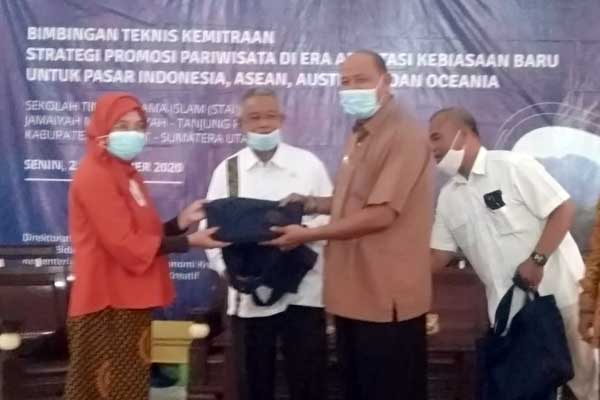 CENDERAMATA: Wabup Langkat, Syah Afandin menyerahkan cenderamata kepada anggota Komisi X DPR RI, Prof.Djohar Arifin Husin pada kegiatan bimtek. ILYAS EFFENDY/ SUMUT POS.