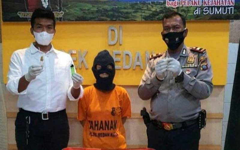 DIPAPARKAN: Tersangka E (tengah), tukang cuci pecandu sabu-sabu dipaparkan Polsek Medan Kota, Rabu (25/11).