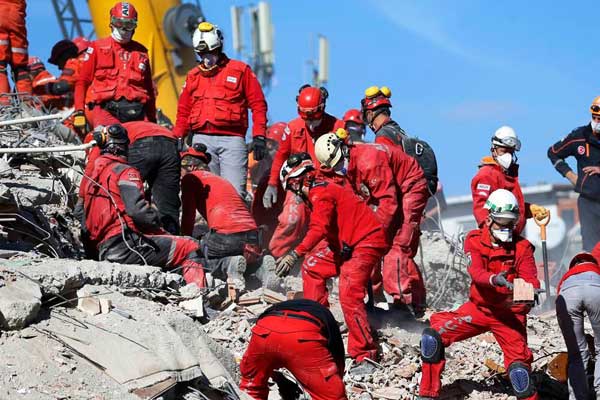 CARI KORBAN Petugas mencari korban di antara puing-puing bangunan paskagempa kuat yang mengguncang Pantai Aegea, Turki, Minggu (1/11) pagi waktu setempat.