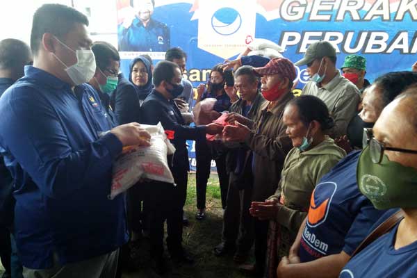 SERAHKAN: Ketua DPD Partai Nasdem Kabupaten Dairi, Nasib Marudur Sihombing saat menyerahkan paket sembako kepada warga, dalam merayakan HUT ke-9 Nasdem, Rabu (11/11).RUDY SITANGGANG/SUMUT POS.