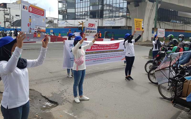 SOSIALISASI: PT KAI saat menyampaikan sosialisasi keselamatan berlalu lintas kepada masyarakat pengguna kendaraan bermotor di persimpangan perlintasan kereta api.