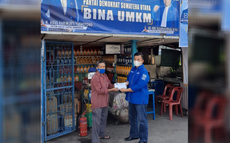 BANTUAN: Plt Ketua DPD Partai Demokrat Sumut, Herri Zulkarnain Hutajulu, saat memberikan bantuan kepada pelaku UMKM pengecer BBM di Jalan Gatot Subroto Medan, Sabtu (21/11).