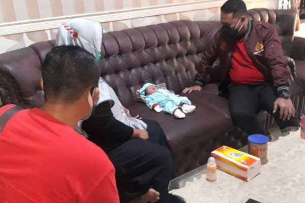 DITEMUKAN: Petugas Polres Sergai saat melihat kondisi bayi yang ditemukan di teras rumah warga.