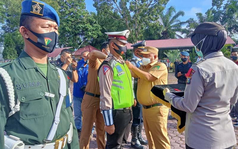 SEMATKAN: Bupati Langkat, Terbit Rencana PA menyematkan pita kepada personel Polres Langkat dalam gelaran apel pasukan Operasi Lilin Toba 2020. ILYAS EFFENDY/ SUMUT POS.