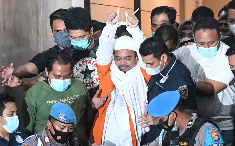 DITAHAN: Imam Besar FPI Habib Rizieq Shihab mengenakan rompi tahanan warna oranye dengan tangannya diborgol plastik warna putih usai menjalani pemeriksaan selama 14 jam, Sabtu (12/12) malam.