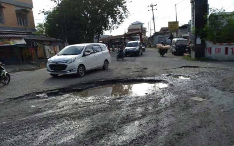 BERLUBANG: Pengendara menghindari lubang di Jalan Titi Pahlawan, Medan Marelan. Jalan ini butuh perbaikan.fachril/sumu tpos.