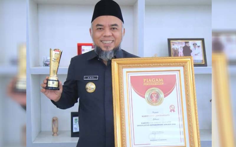 PENGHARGAAN: Bupati Labuhanbatu, Andi Suhaimi memperlihatkan penghargaan IGA 2020 yang diberikan Mendagri.