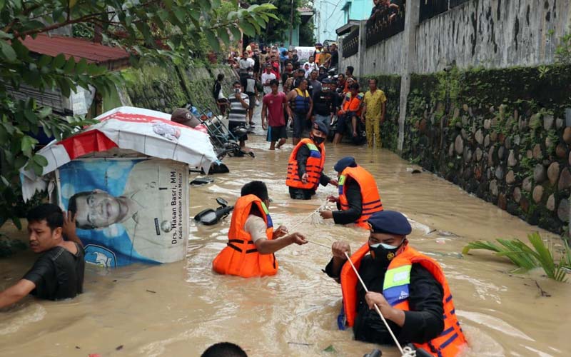 EVAKUASI: Personel Polda Sumut dan Sat Brimob membantu evakuasi warga korban banjir di Jalan Brigjend Katamso Kecamatan Medan Maimun Kelurahan Sei Mati Medan, Jumat (4/12).