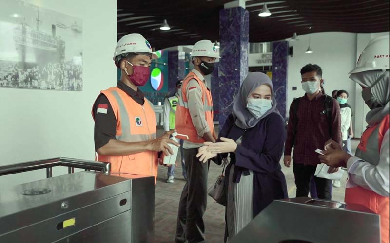 TINJAU: Petugas menyemprotkan cairan hand sanitizer kepada calon penumpang di Terminal Bandar Deli Pelabuhan Belawan. PT Pelindo I mengajak para calon penumpang untuk terus menegakkan protokol kesehatan.fachril/sumut pos.