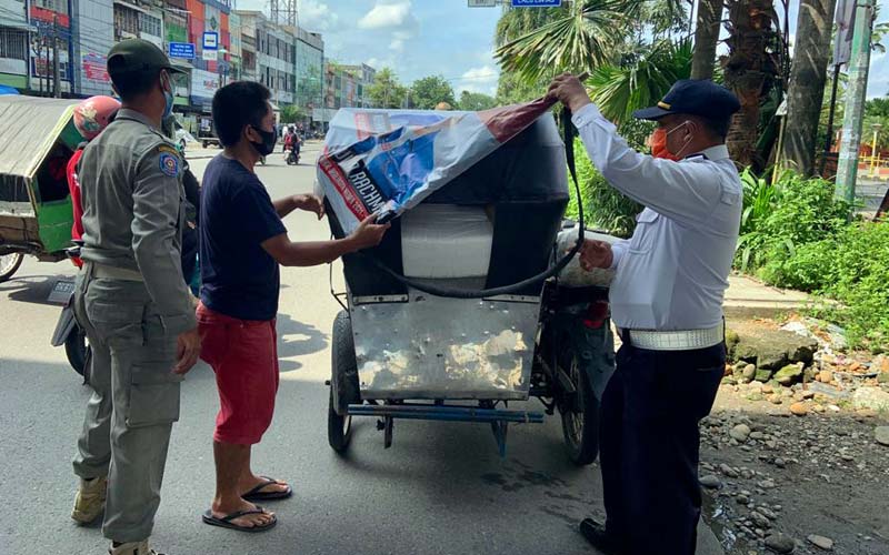 Tertibkan APK: Personel Dishub Kota Medan bersama Satpol PP saat menertibkan APK yang terpasang di salah satu becak bermotor.istimewa/sumut pos.