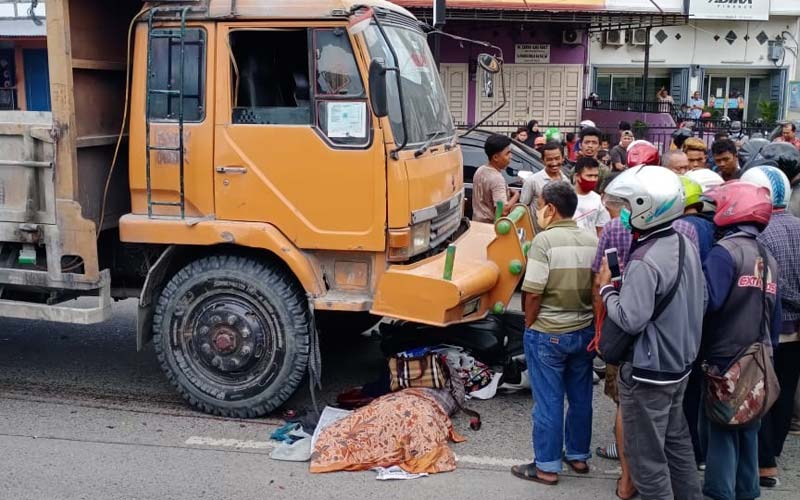 DITABRAK: Sejumlah warga melihat jasad warga Jalan Luku I yang ditabrak truk tronton di Jalan AH Nasution, Titi Kuning, Kamis (3/12). 