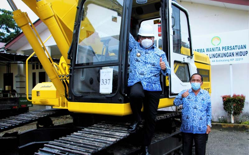 HIBAH: Bupati Dairi, Dr Eddy Keleng Ate Berutu (kiri) didampingi Kadis Lingkungan hidup diabadikan di atas alat berat jenis escavator hibah dari Kementerian PUPR. RUDY SITANGGANG/SUMUT POS.