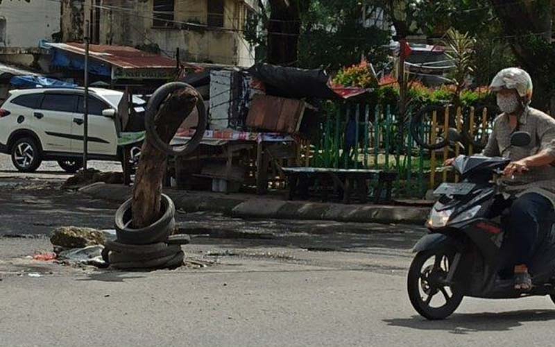 BATANG POHON: Jalan berlubang di Jalan Sutomo, Pusat Pasar, Medan Kota ditimbun batang pohon oleh warga.istimewa/sumut pos.