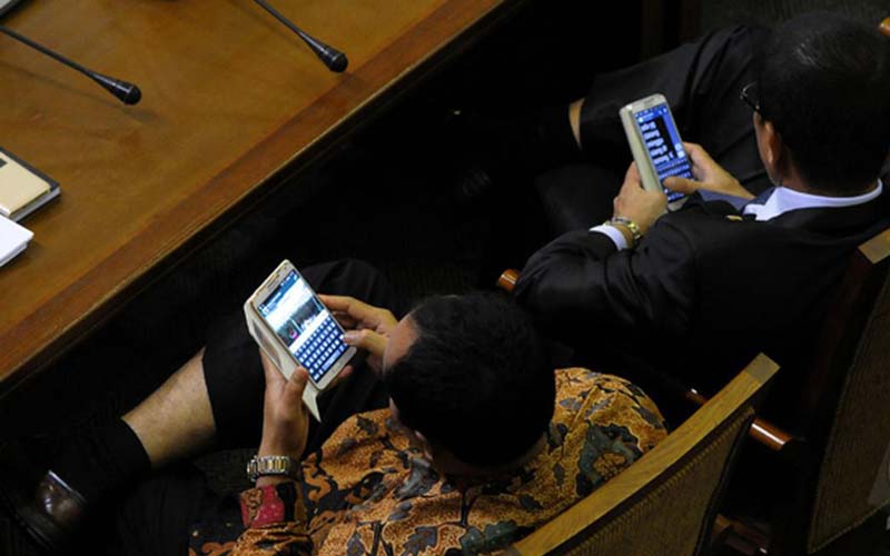 ILUSTRASI: Dua anggota legislatif menggunakan ponselnya sebagai sarana komunikasi. Sedangkan 100 anggota DPRD Sumut mendapat tunjangan komunikasi mencapai Rp108 miliar, di mana per anggota dapat Rp18 juta tiap bulan.
