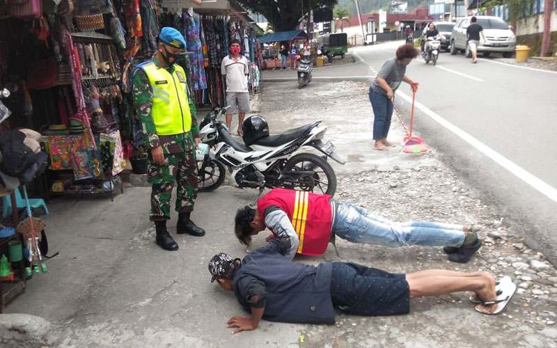 DIHUKUM: Dua warga dihukum push-up karena kedapatan tidak mengenakan masker di kawasan Berastagi.