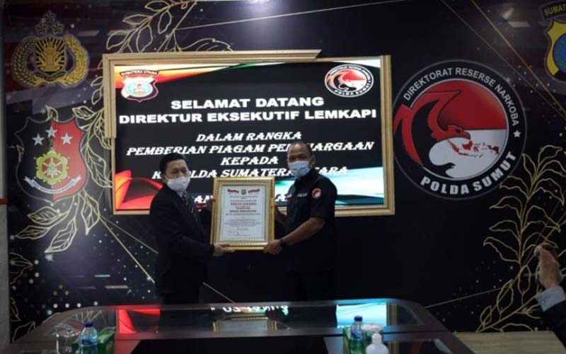 PIAGAM: Mewakli Kapoldasu, Dir Resnarkoba Poldasu,  Kombes Pol C Wisnu Adji P menerima  piagam penghargaan Trust Award.dewi/sumut pos.