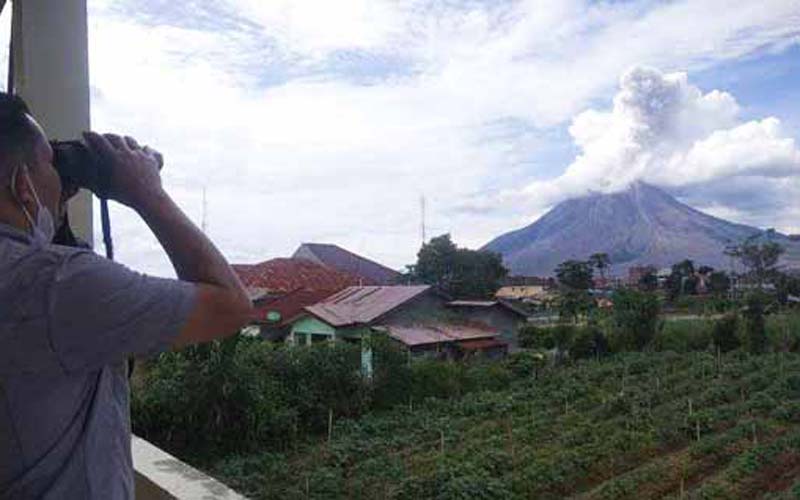 PANTAU: Petugas memantau aktivitas erupsi Gunung Sinabung dari Pos Pemantau, Senin (4/1). Kemarin, Gunung Sinabung kembali erupsi dengan ketinggian kolom abu mencapai 800 meter.