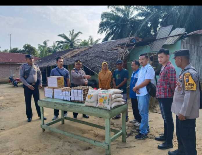 BANTUAN: Personel Polres Langkat saat menyerahkan bantuan untuk warga yang tertimpa bencana Puting Beliung di Dusun V Desa Sei Meran, Langkat.
