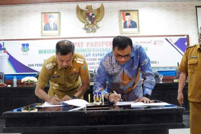 TANDA TANGAN: Pj Wali Kota Tebingtinggi Moettaqien Hasrimi dan Wakil I DPRD Kota Tebingtinggi Muhammad Azwar melakukan tanda tangan bersama Rancangan Peraturan Daerah tentang APBD Tahun Anggaran 2025. FOTO: SOPIAN/SUMUT POS