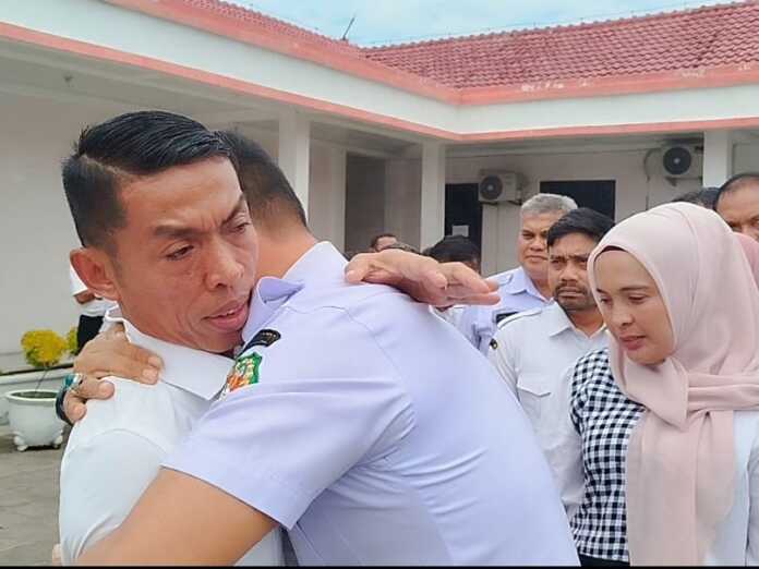 RANGKUL: Salah seorang pegawai merangkul Suwarno pada acara pelepasan usai tak menjabat lagi sebagai Kepala PUD Kota Medan.