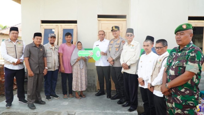 BEDAH RUMAH: Pj Bupati Langkat, H.M. Faisal Hasrimy, AP, MAP, bersama Ketua Baznas Kabupaten Langkat, Thantawi Jauhari, MA, menyerahkan kunci rumah kepada Nurlela, korban kebakaran. FOTO: SYAHRUL/SUMUT POS