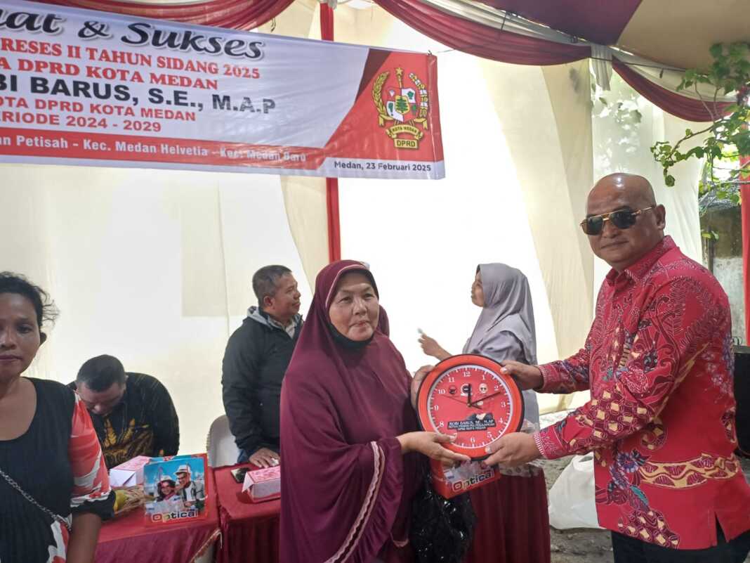 Foto (Markus Pasaribu/Sumut Pos) : Ketua Fraksi PDIP DPRD Medan, Robi Barus SE M.AP memberikan cinderamata kepada Mahrani Purba yang hadir pada pelaksana Reses di Jalan Setia Luhur, Minggu (23/2/2025).