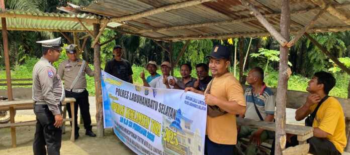 PASANG SPANDUK: Personel Polres Labusel memasang spanduk dalam pelaksanaan Operasi Keselamatan Toba 2025. KHAIRUDDIN/SUMUTPOS