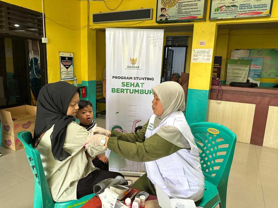 PERIKSA: Tim medis Baznas sumut melakukan pemeriksaan tekanan darah pada seorang ibu. FOTO:ISTIMEWA/SUMUT POS