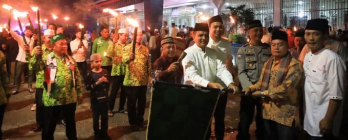 PAWAI OBOR: Plh Sekda Drs H. Fuadi M.AP melepas pawai obor di Kecamatan Kota Pinang yang digelar di gedung Santun Berkata Bijak Berkarya, Kecamatan Kota Pinang, Kamis (27/2/2025)malam. FOTO: KHAIRUDDIN/SUMUT POS