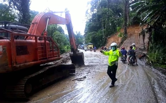 LONGSOR: Petugas kepolisian mengatur lalu lintas saat Jalur Medan-Berastagi, putus akibat tertutup longsor dan pohon tumbang di kawasan Lau Kaban, Sibolangit, Deliserdang, beberapa waktu lalu. dok/sumut pos.