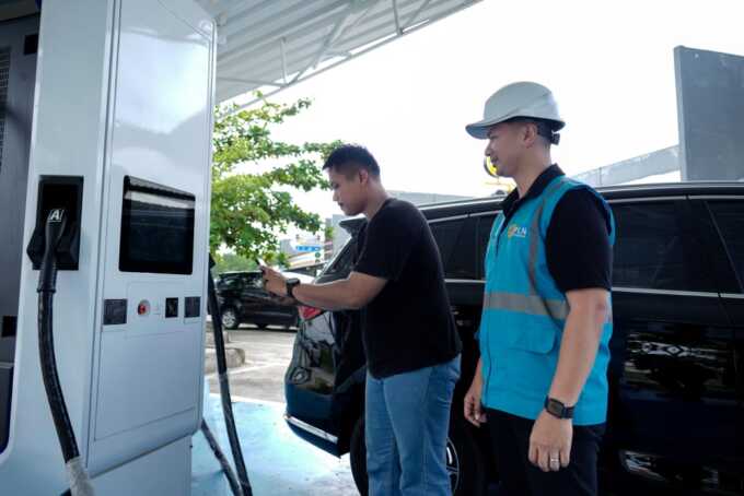 Pengguna kendaraan listrik saat melakukan scan pengisian baterai pada SPKLU didampingi oleh petugas PLN