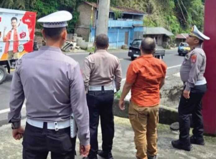 PASANG: Personel Satlantas Polres Tanah Karo saat memasang CCTV di titik strategis.