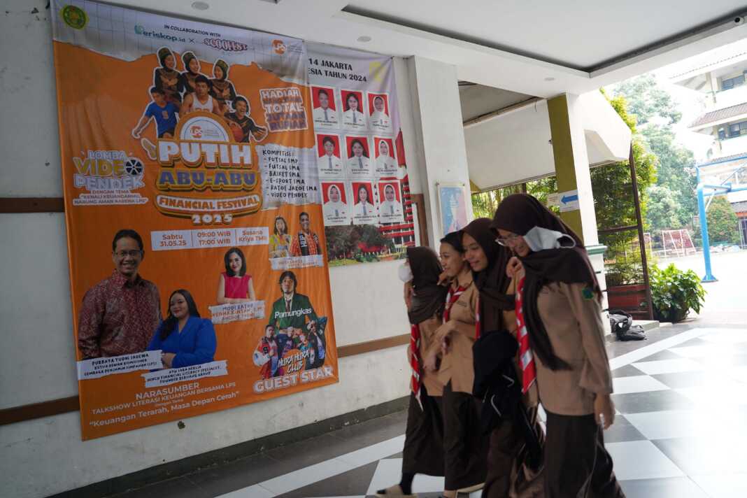 Siswa melintas di samping banner LPS Putih Abu-Abu Financial Fest di SMAN 14 Jakarta, Rabu (28/5/2025). (Arief Rachman/ dok. LPS)